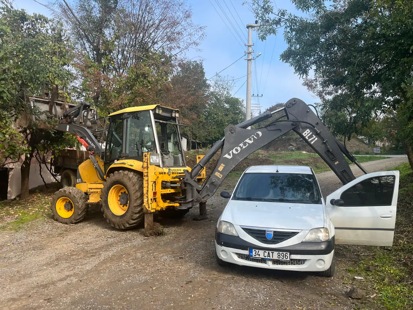Kırsal yolda işe hazır bekleyen Kanbil Hafriyat beko-loder'i